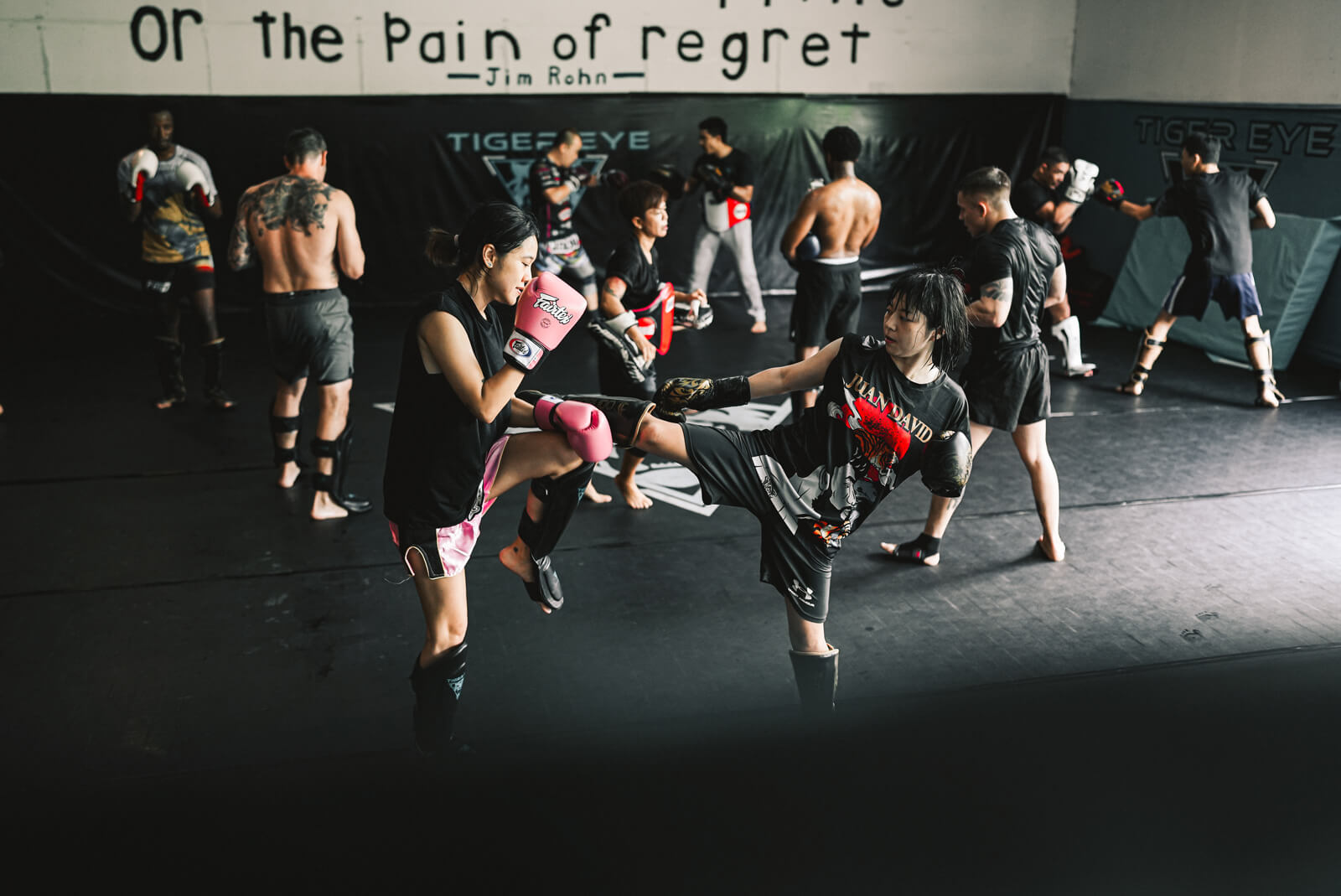 Group Muay Thai class at Tiger Eye, with a student throwing a kick in the foreground