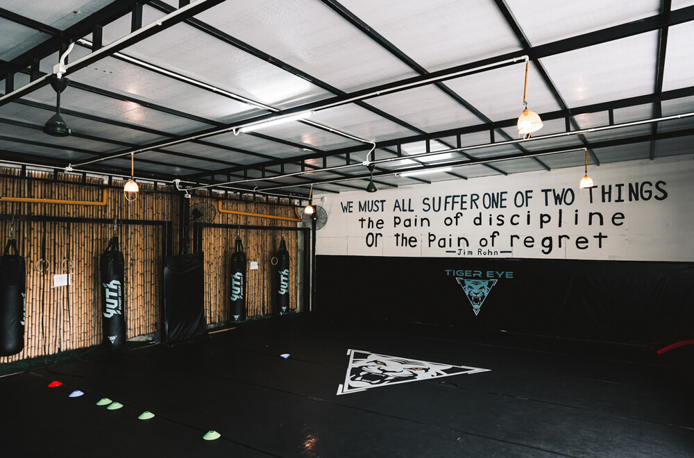 Training floor inside Tiger Eye MMA with ring and heavy bags
